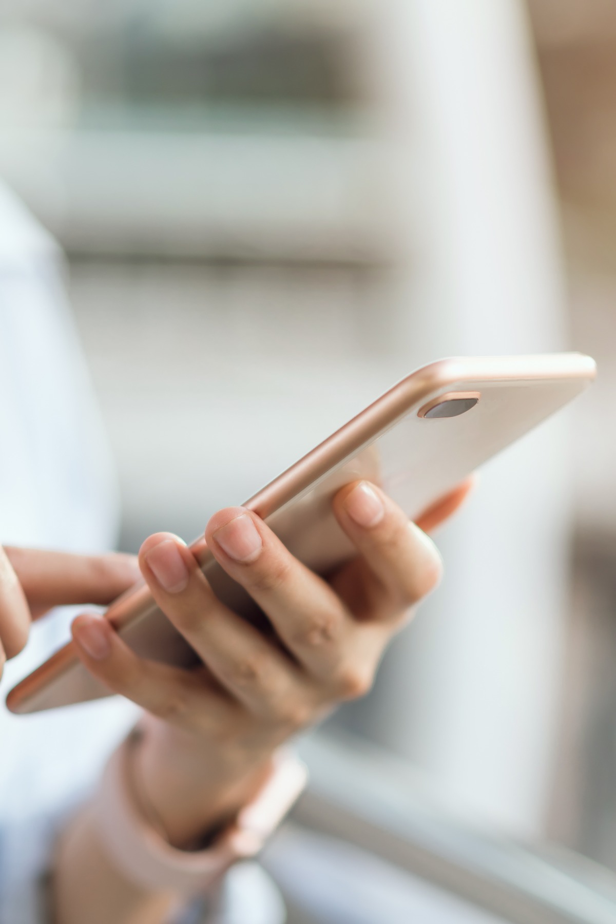Frau, die in öffentlichen Bereichen auf einer Treppe ihr Smartphone benutzt, in ihrer Freizeit. Die Nutzung des Telefons ist aus dem Alltag nicht mehr wegzudenken.