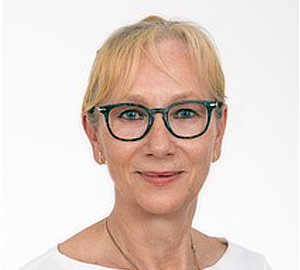 Lächelnde blonde Frau mit grüner Brille vor weißem Hintergrund